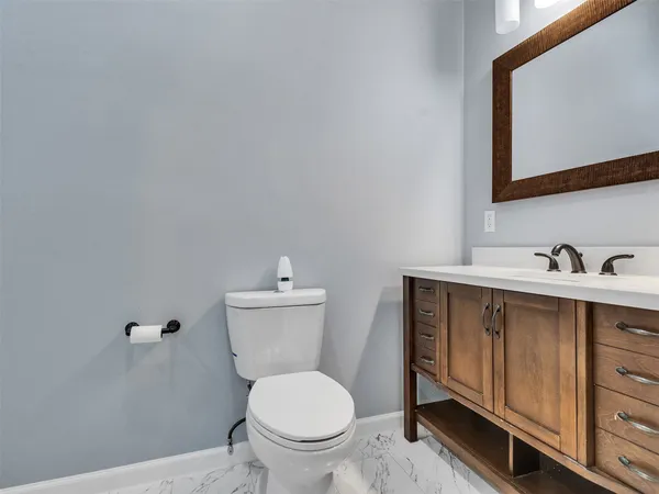 a bathroom with a toilet a sink and mirror