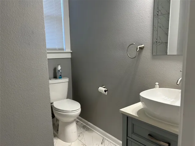 a bathroom with a toilet a sink and mirror