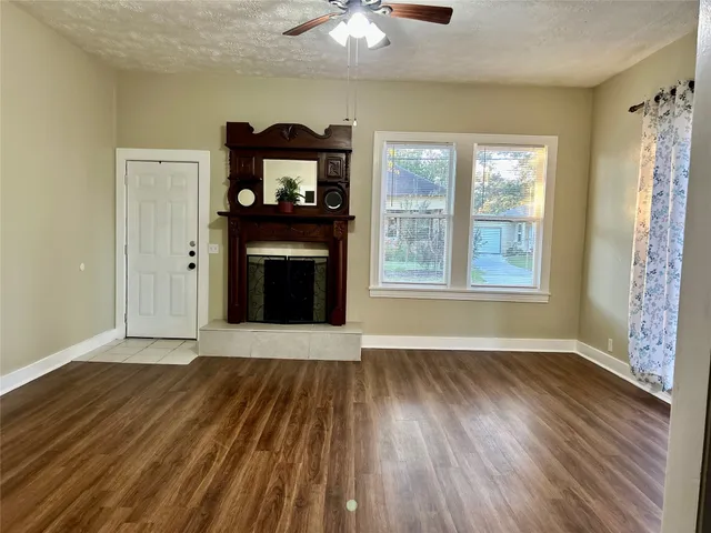 an empty room with windows and a ceiling fan
