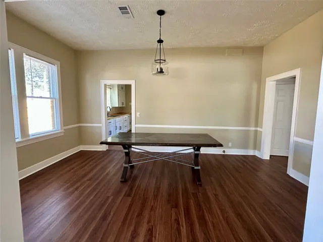 a view of a room with wooden floor table and chairs