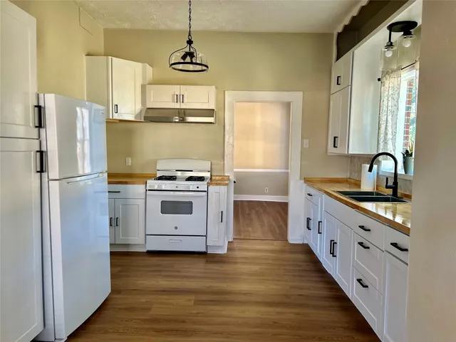 a kitchen with stainless steel appliances a stove a sink and a refrigerator