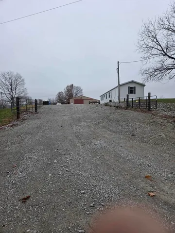 a view of a dry yard with wooden fence