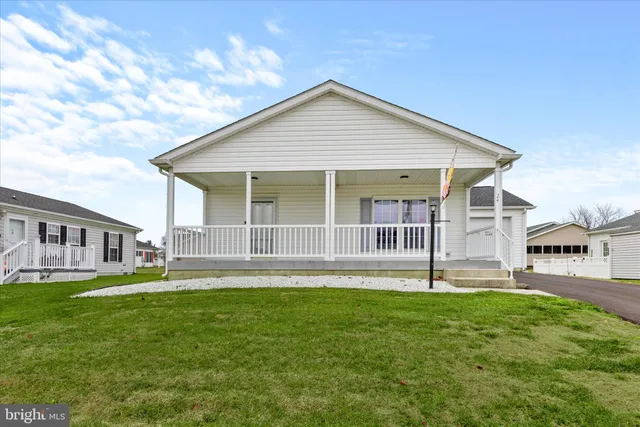an empty room with wooden floor and a chandelier