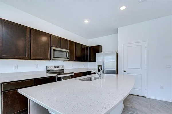 a kitchen with stainless steel appliances a microwave a sink a stove and cabinets