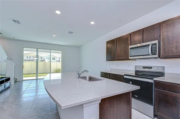a kitchen with stainless steel appliances a stove a sink a microwave a refrigerator and cabinets