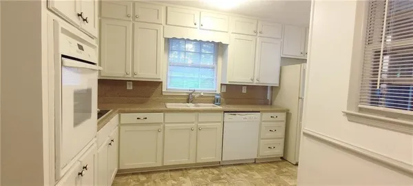a kitchen with stainless steel appliances cabinets and a window