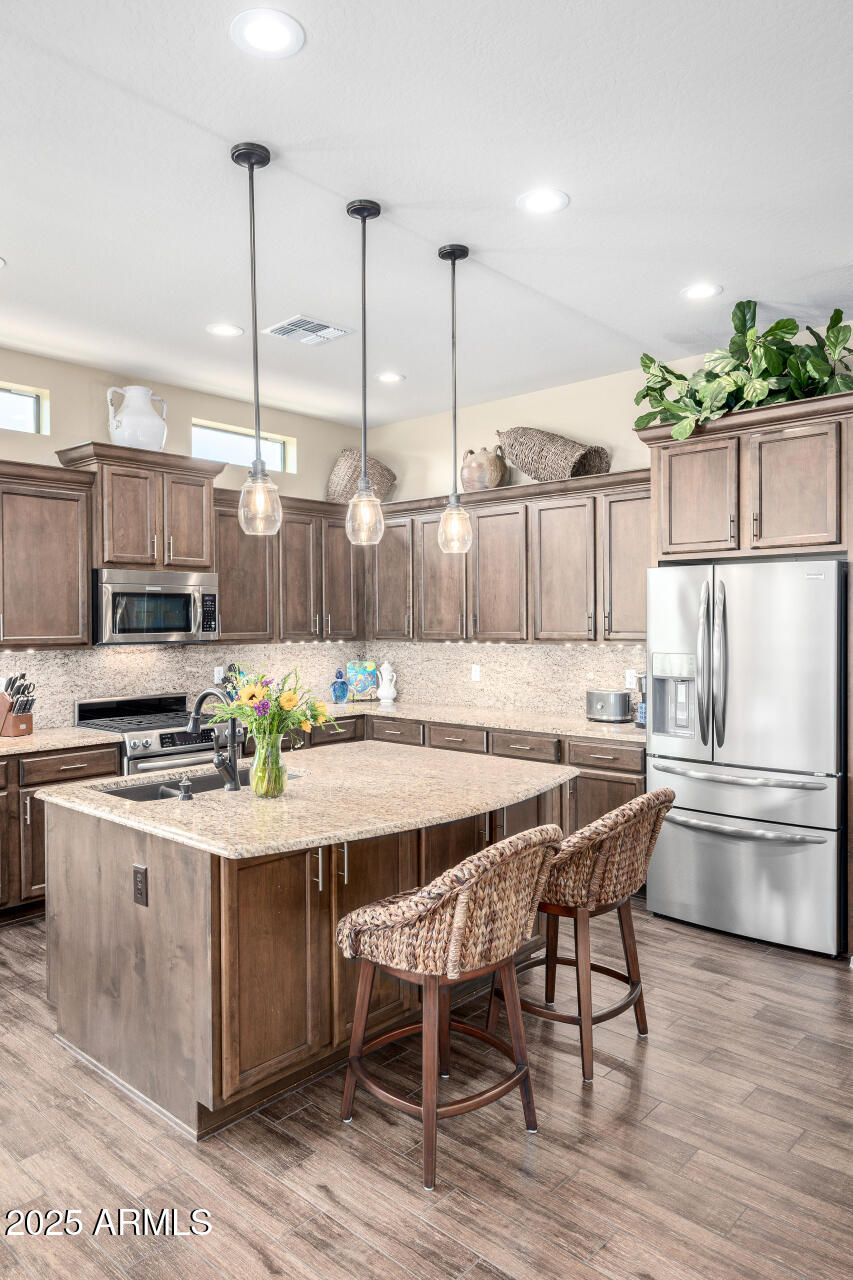 1822 North Waverly Mesa, AZ 85207 - Photo 33 of 91 a kitchen with stainless steel appliances kitchen island granite countertop a table chairs and a stove