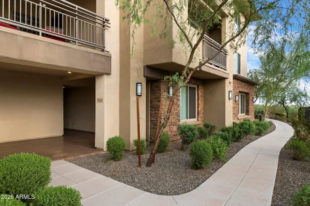 a view of a house with brick walls and plants