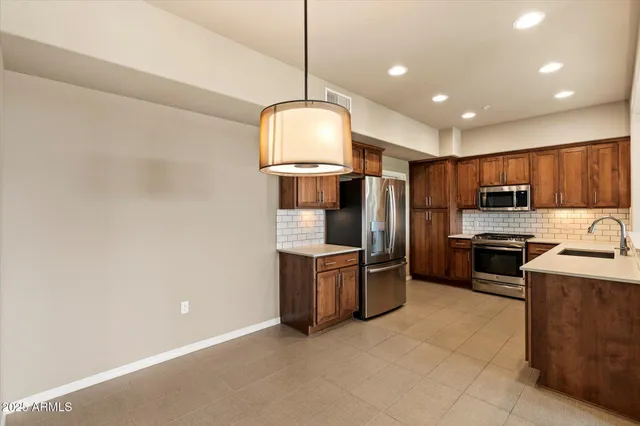 a kitchen with stainless steel appliances granite countertop a sink a stove and a refrigerator