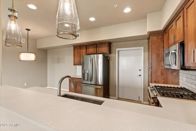 a kitchen with stainless steel appliances granite countertop a refrigerator and a stove top oven