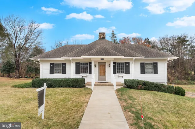 a front view of a house with a yard and trees