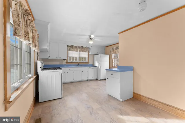 a kitchen with stainless steel appliances granite countertop a stove a sink and white cabinets
