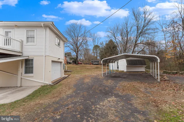 a view of a house with a yard and large tree