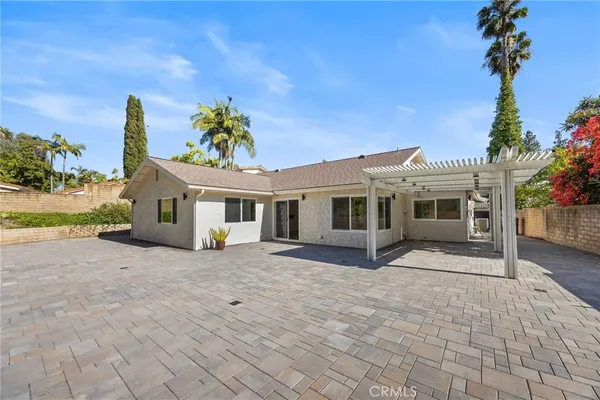 a view of a house with a yard and potted plants