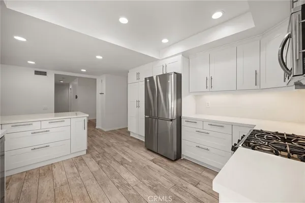 a kitchen with a refrigerator and a stove top oven