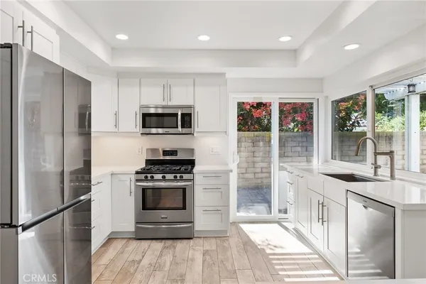 a kitchen with granite countertop a refrigerator and a stove top oven