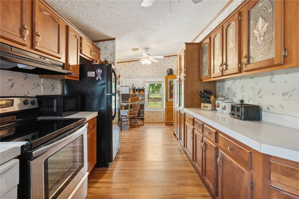4131 Burwell Road Webster, FL 33597 - Photo 14 of 61 a kitchen with stainless steel appliances granite countertop a refrigerator a stove and a sink