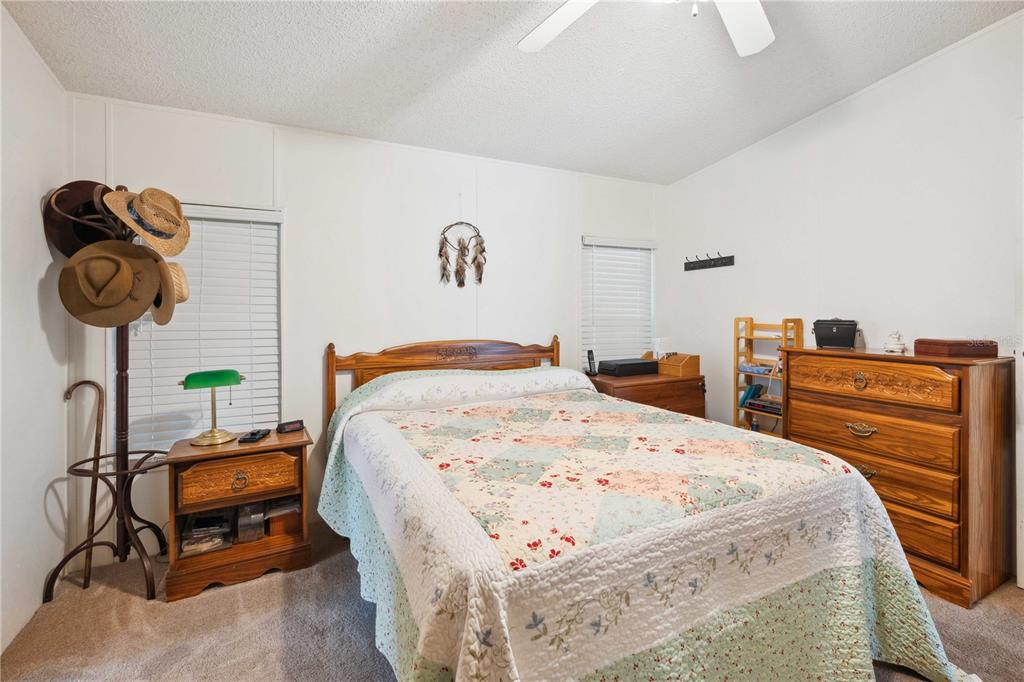 4131 Burwell Road Webster, FL 33597 - Photo 21 of 61 a bedroom with a bed a dresser and potted plants