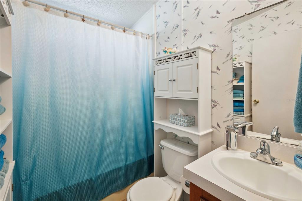 4131 Burwell Road Webster, FL 33597 - Photo 28 of 61 a bathroom with a sink a toilet and shower curtain