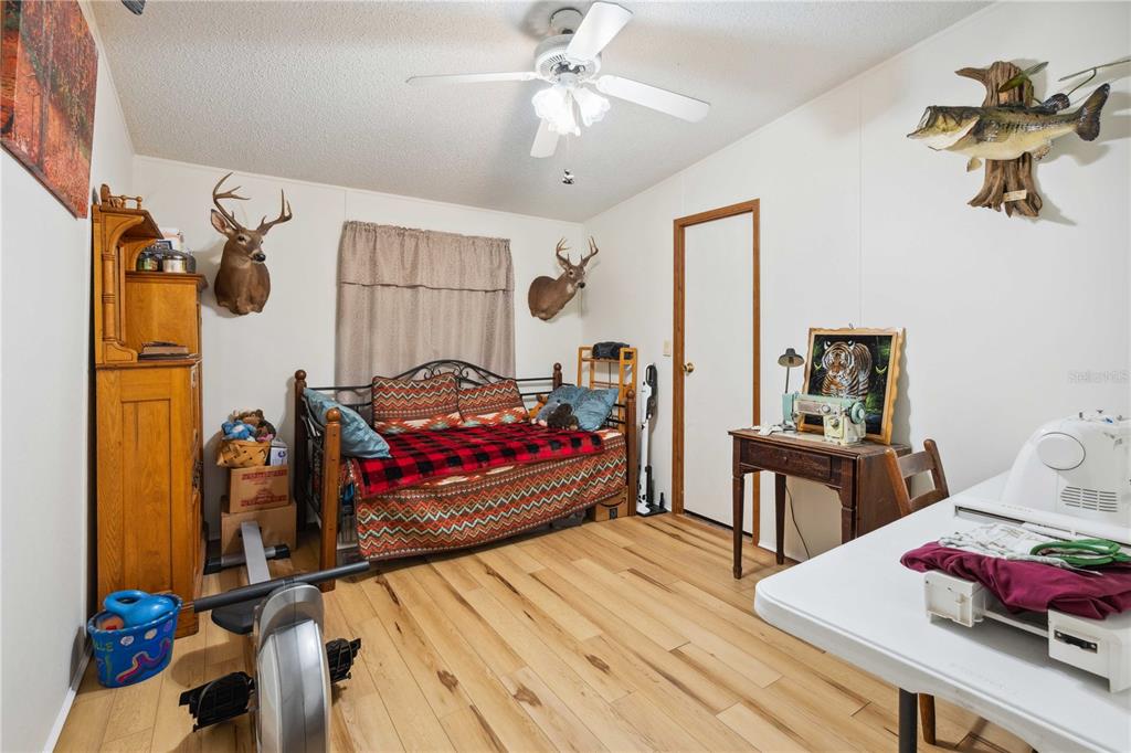 4131 Burwell Road Webster, FL 33597 - Photo 30 of 61 a bedroom with a bed and wooden floor