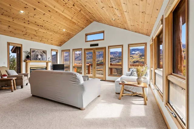 a living room with furniture large window and flat screen tv