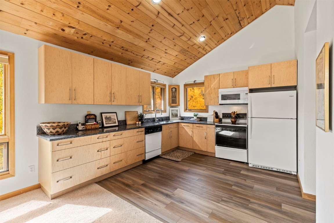 1007 Blue Ridge Road Silverthorne, CO 80498 - Photo 35 of 50 a kitchen with granite countertop a refrigerator oven a sink dishwasher and white cabinets with wooden floor