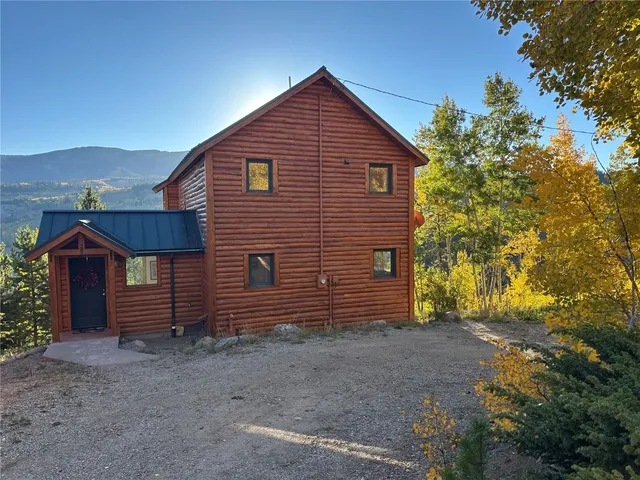 a view of a house with a yard and wooden fence