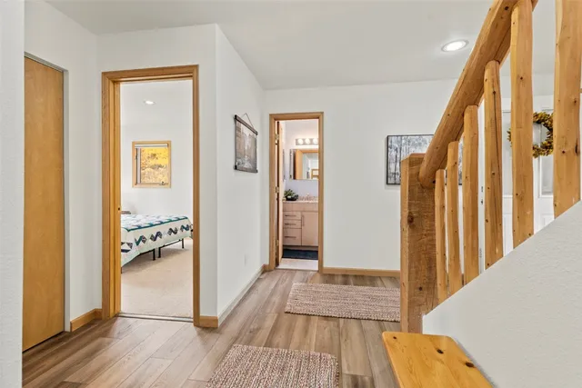 a view of a hallway with wooden floor and staircase