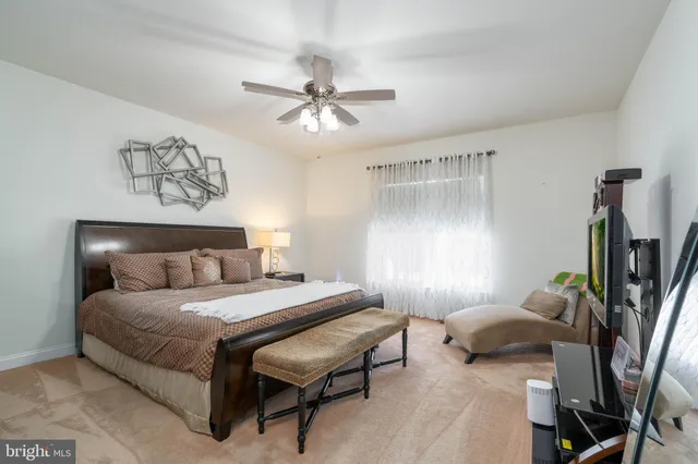 a bedroom with a bed couch and a flat tv screen