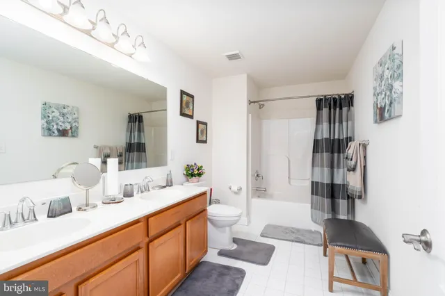 a bathroom with a double vanity sink mirror and shower