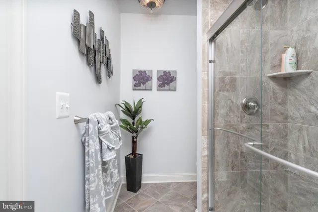 a vase of flowers sitting on a bathroom with a shower