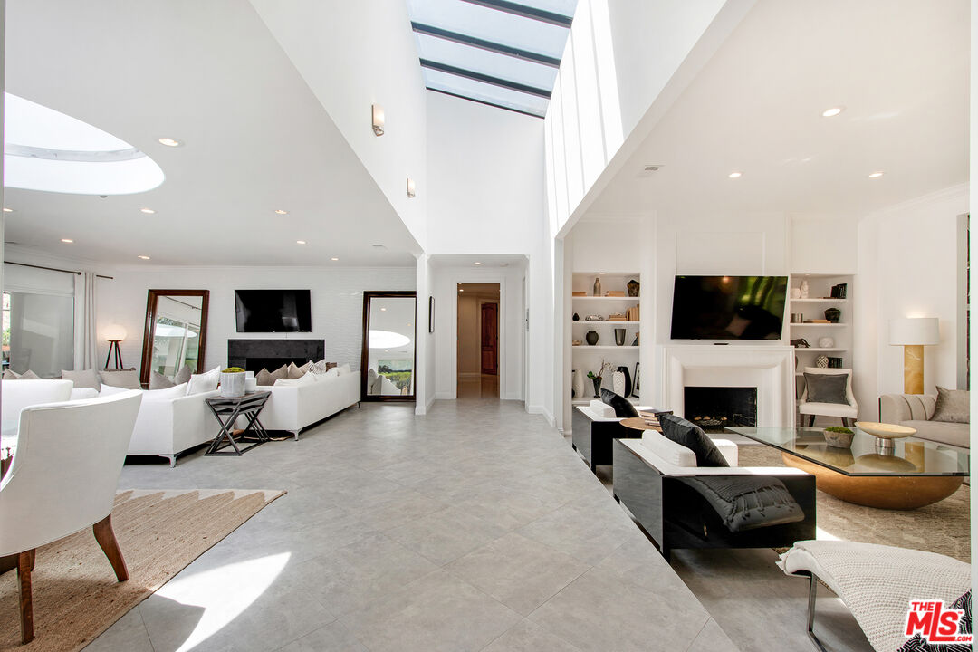 9696 Antelope Road Beverly Hills, CA 90210 - Photo 8 of 29 a living room with furniture a fireplace and a flat screen tv