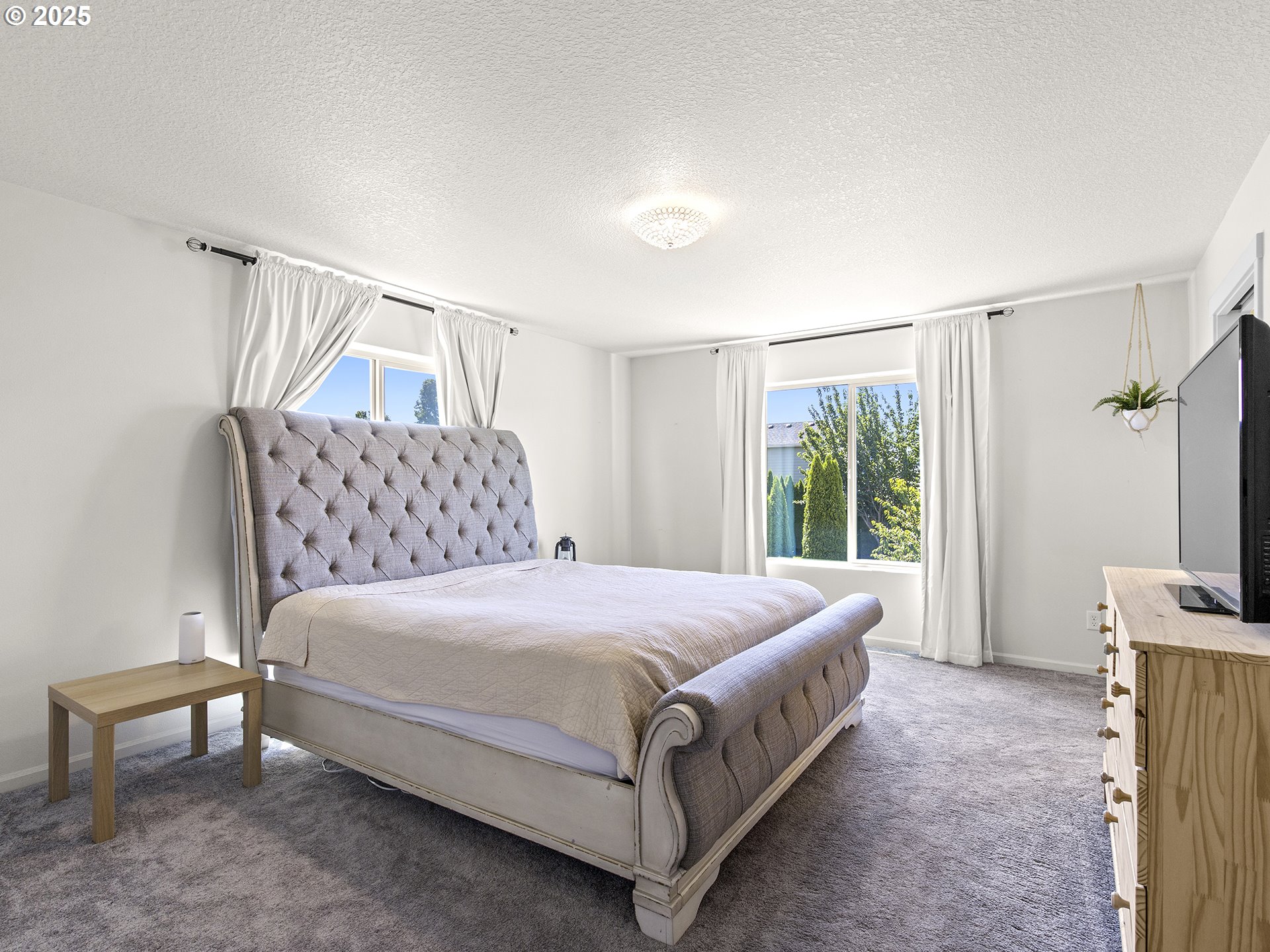 3805 North 3rd Circle Ridgefield, WA 98642 - Photo 12 of 30 a bedroom with a bed flat screen tv and a large window