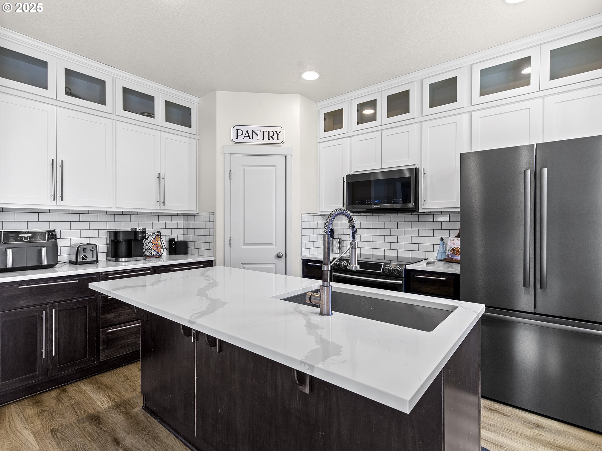 3805 North 3rd Circle Ridgefield, WA 98642 - Photo 3 of 30 a kitchen with a sink a microwave a refrigerator and cabinets