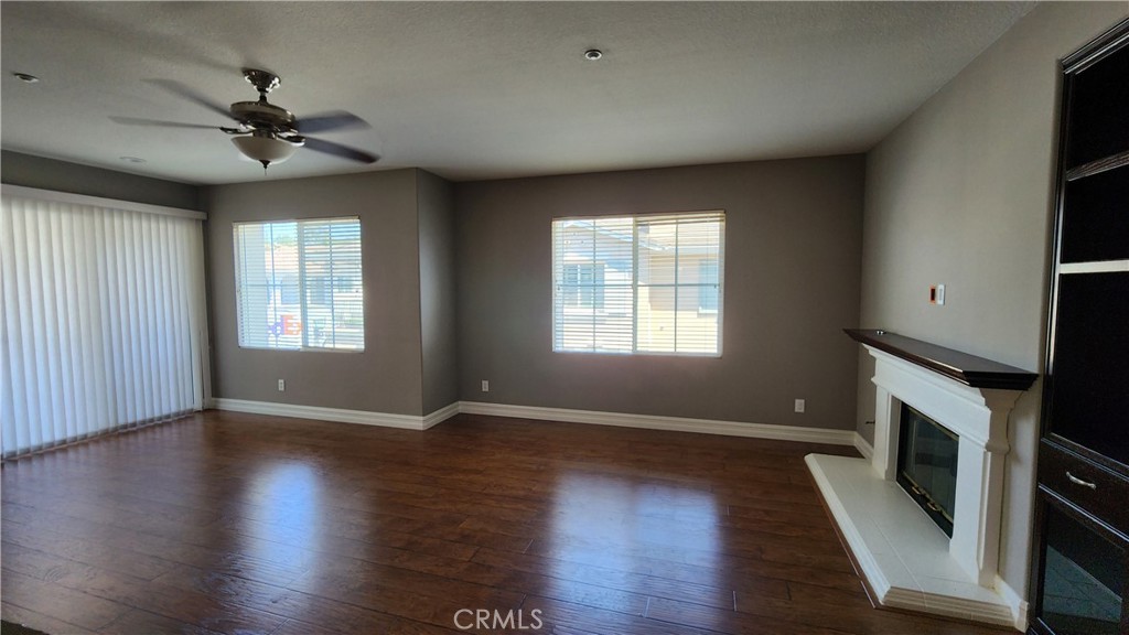 3 Camino Celeste San Clemente, CA 92673 - Photo 6 of 16 an empty room with wooden floor chandelier fan and windows