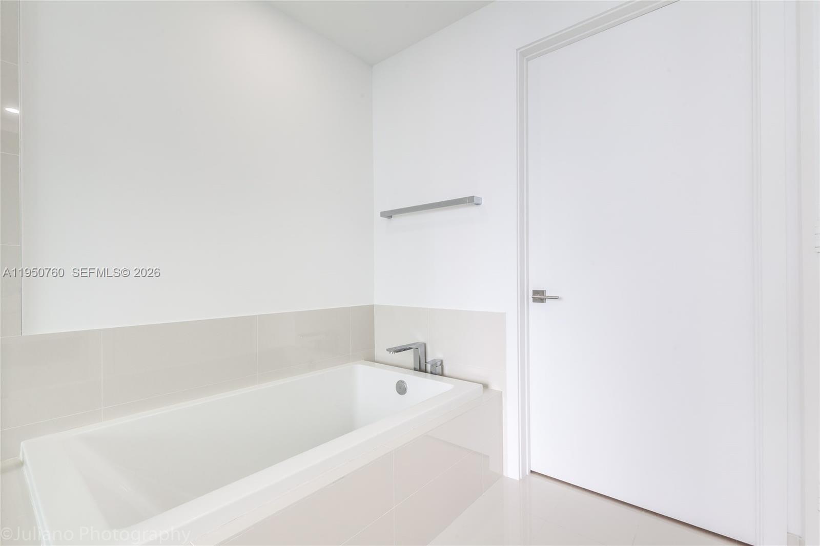 55 Southwest 9th Street, Unit PH4603 Miami, FL 33130 - Photo 24 of 48 a white bath tub sitting next to a white sink and vanity