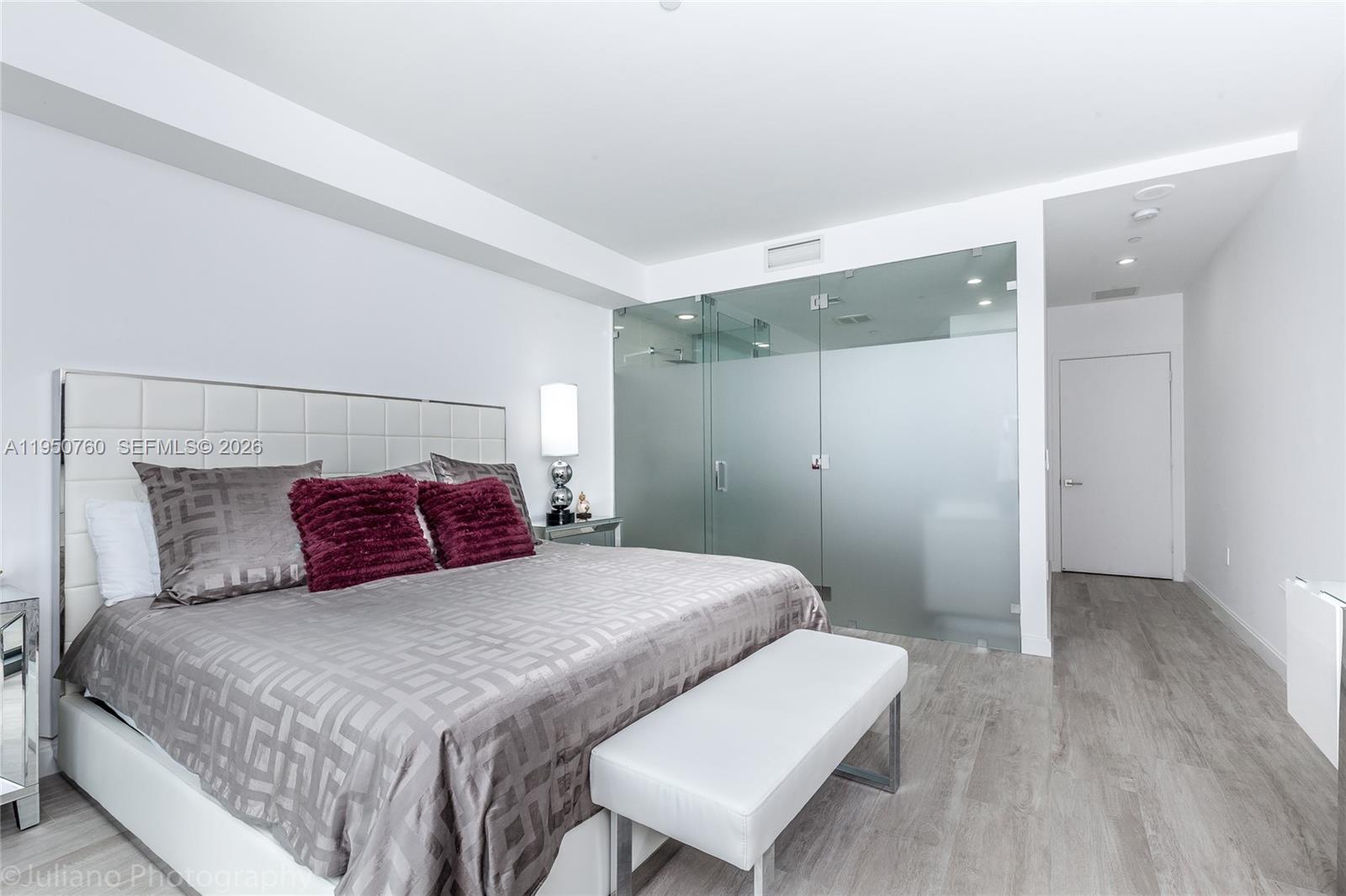 55 Southwest 9th Street, Unit PH4603 Miami, FL 33130 - Photo 29 of 48 a bedroom with a large bed and a chair