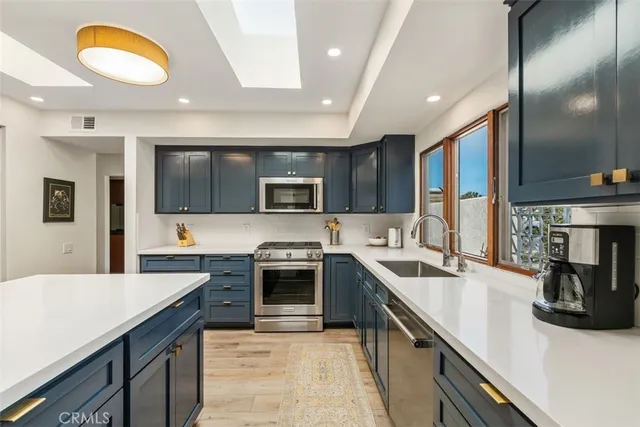 a kitchen with stainless steel appliances granite countertop a sink and stove top oven