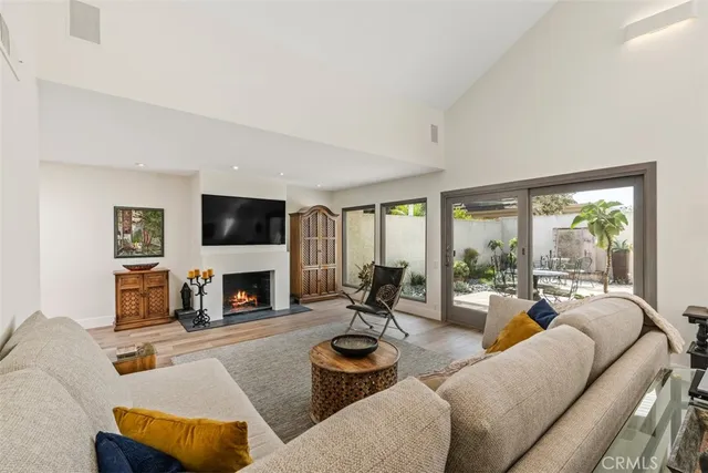 a living room with furniture fireplace and a large window