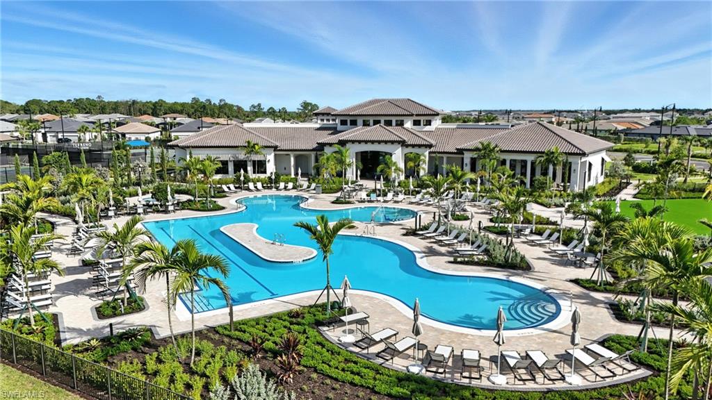 2148 Sequoia Court Naples, FL 34113 - Photo 40 of 48 a view of a patio with couches table and chairs under an umbrella