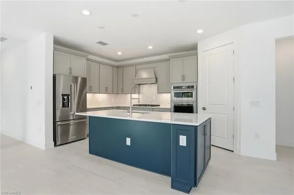 a kitchen with kitchen island stainless steel appliances cabinets and refrigerator
