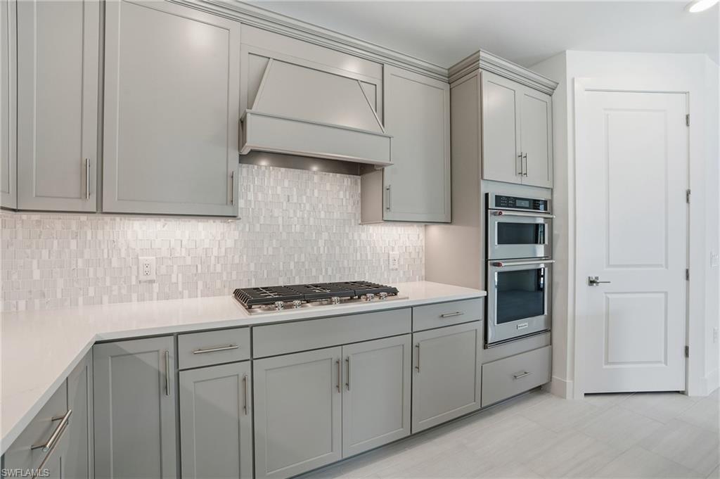 2148 Sequoia Court Naples, FL 34113 - Photo 9 of 48 a kitchen with stainless steel appliances white cabinets and a sink