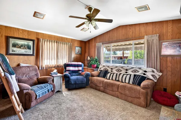 a living room with furniture ceiling fan and a rug