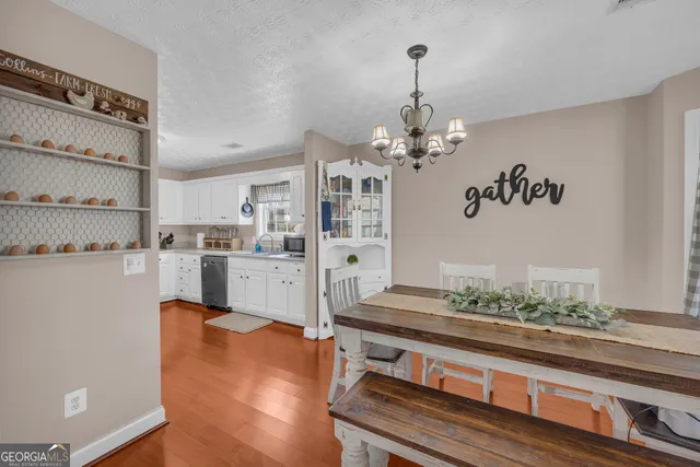 a living room with kitchen island furniture and a chandelier
