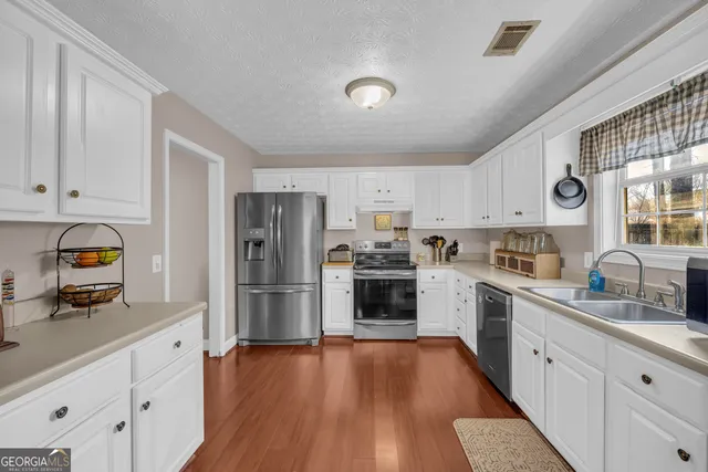 a kitchen with white cabinets and stainless steel appliances