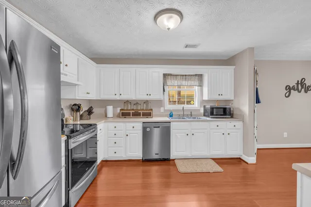 a kitchen with white cabinets and white appliances