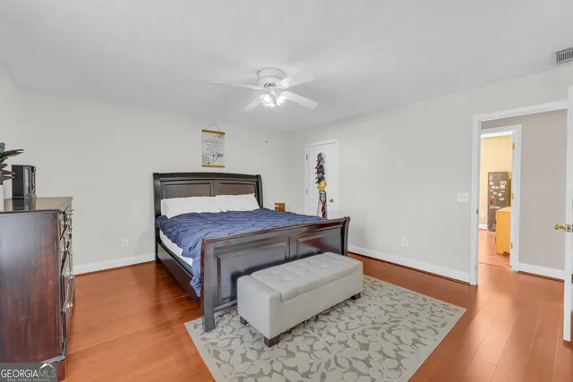 a bedroom with a bed rug and wooden floor