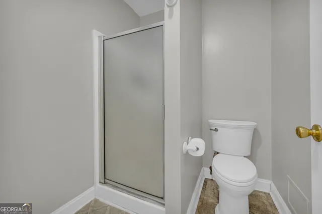 a bathroom with a toilet and a shower