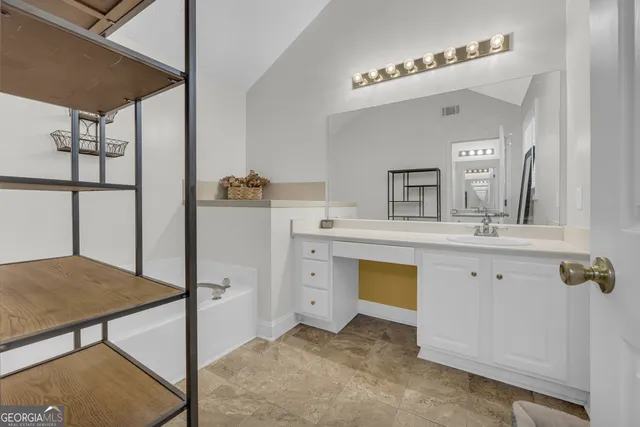 a bathroom with a sink vanity and mirror