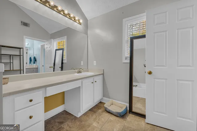 a spacious bathroom with a double vanity sink and a mirror